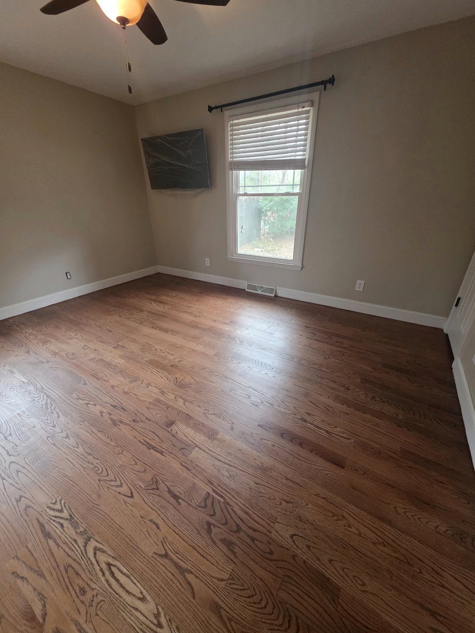 Wood floor in a bedroom with a ceiling fan