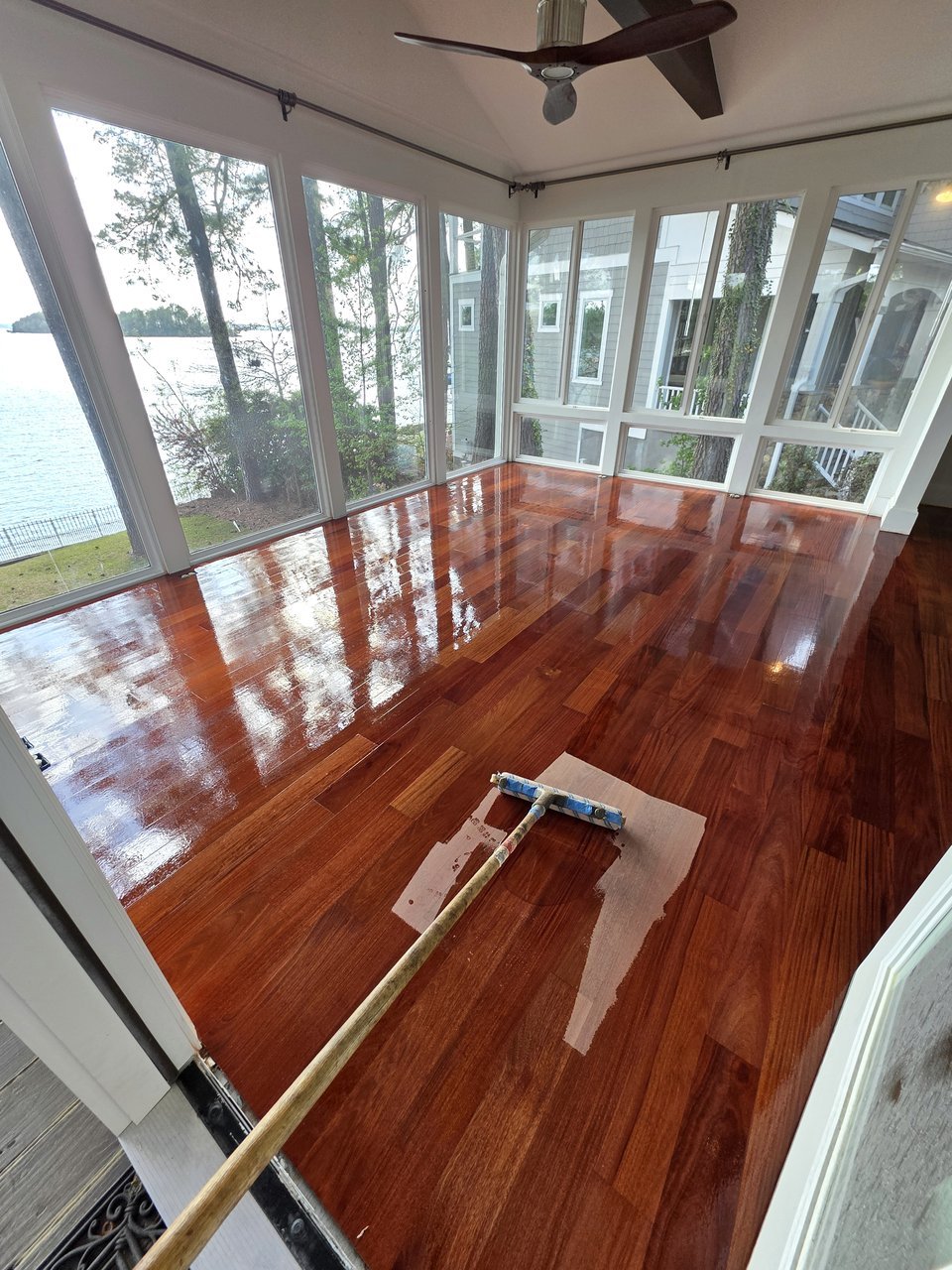 Red-toned floor beside a wall of windows