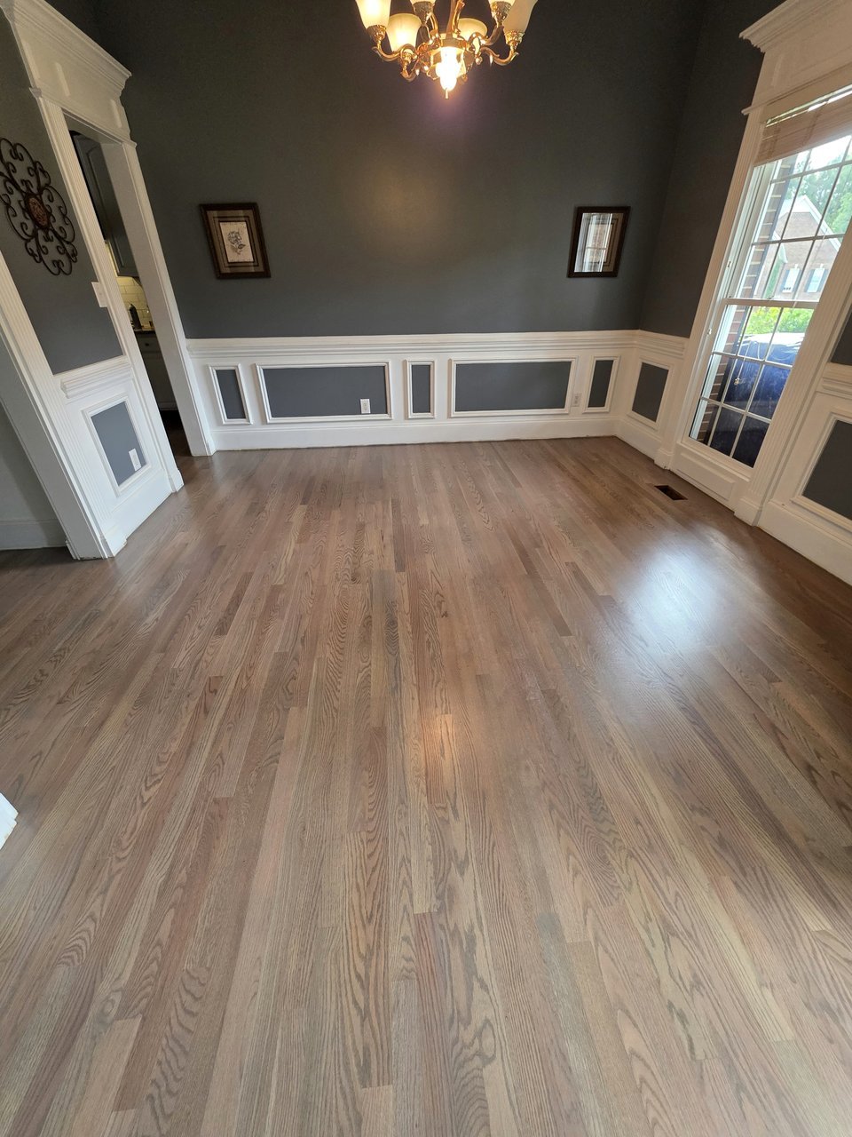 Light wood flooring in a dining room with white paneling