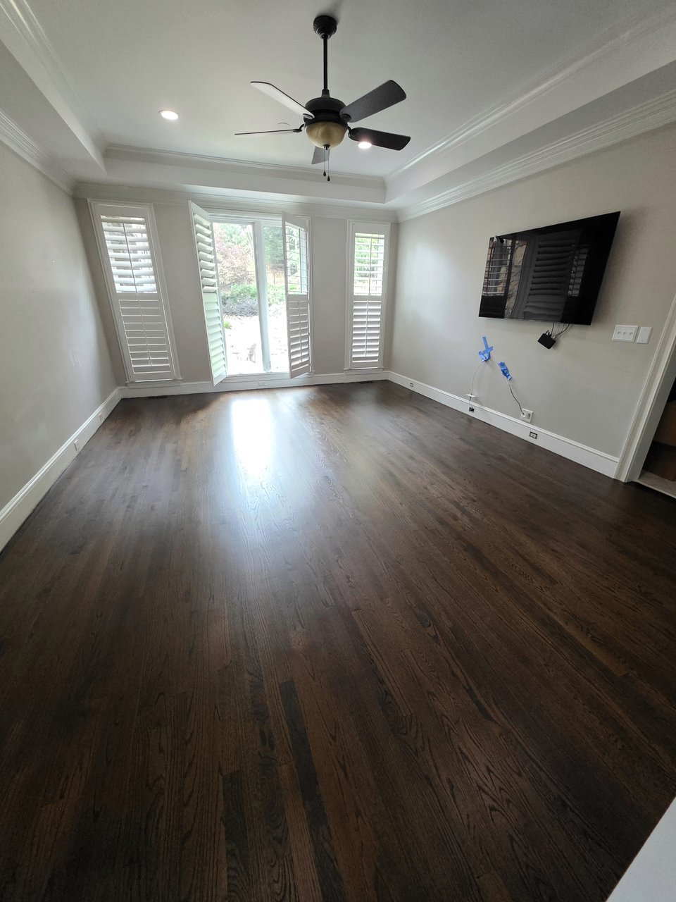Wood flooring in a long room with a ceiling fan