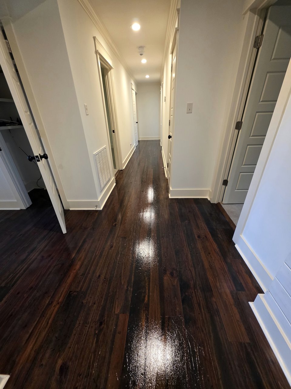 Finished dark wood floor along a hallway