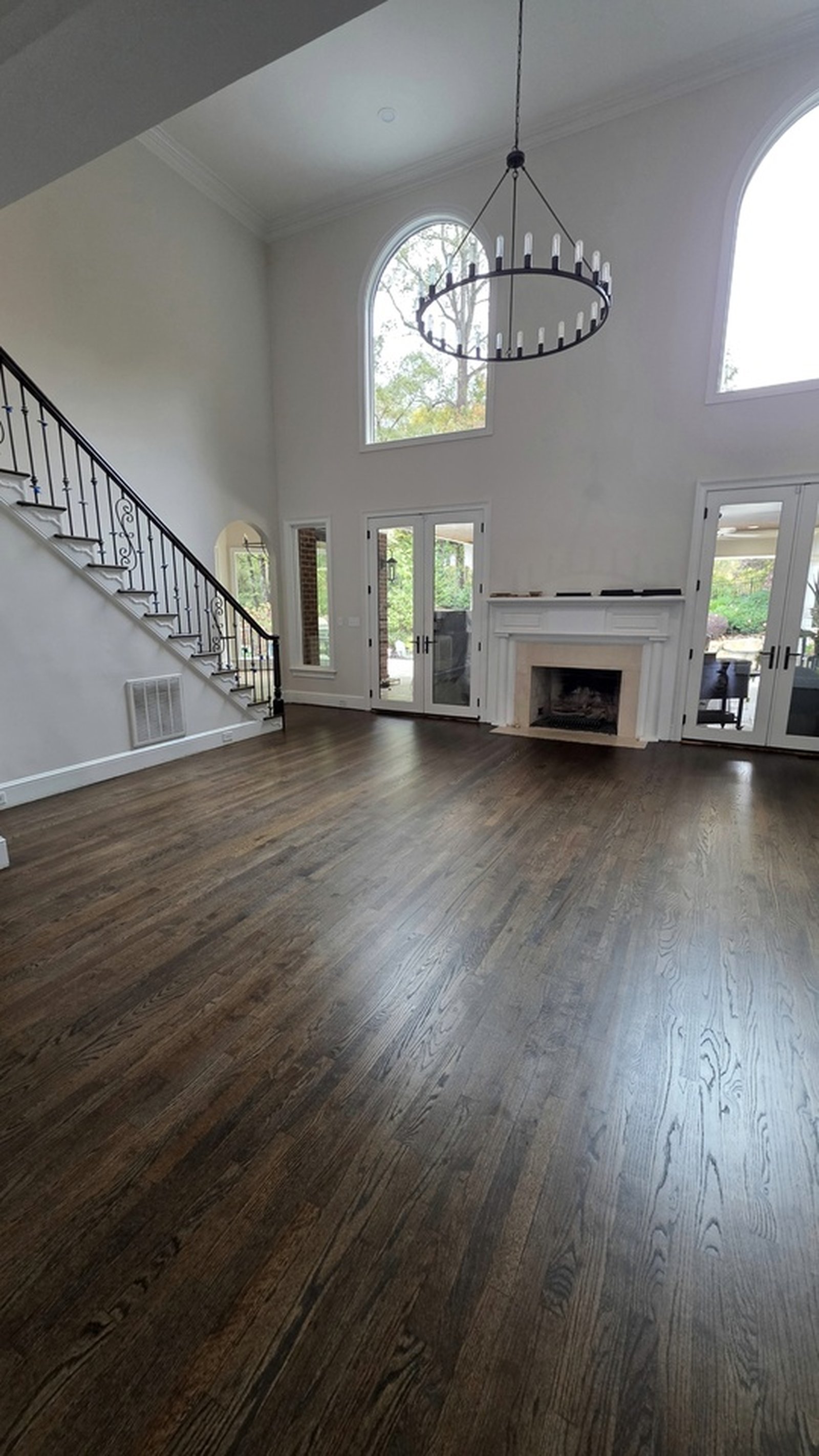 Refinished dark wood floor in a bright double-height living room