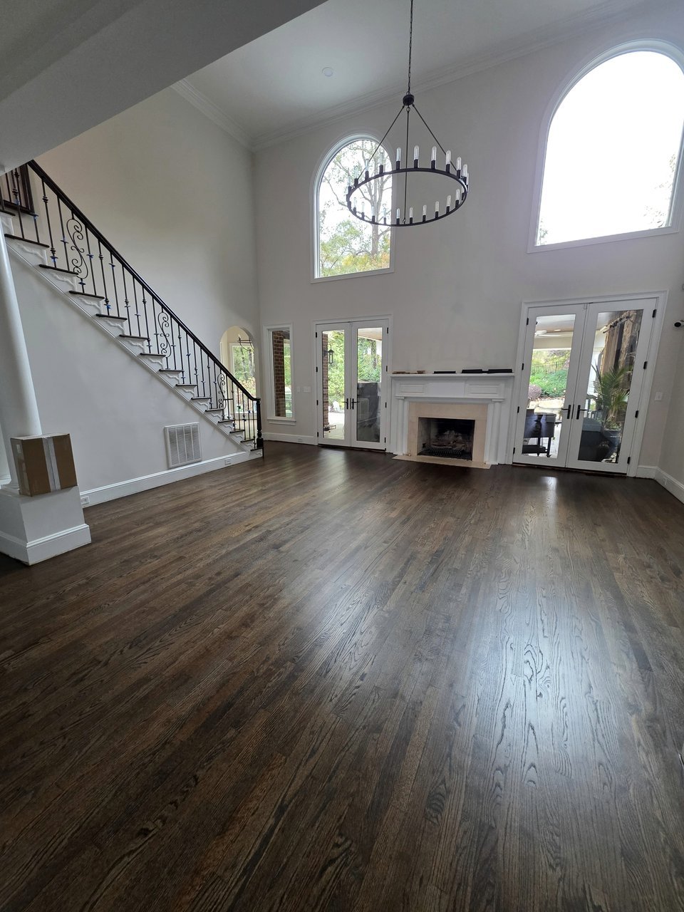 Dark wood floor in a bright living room with tall windows