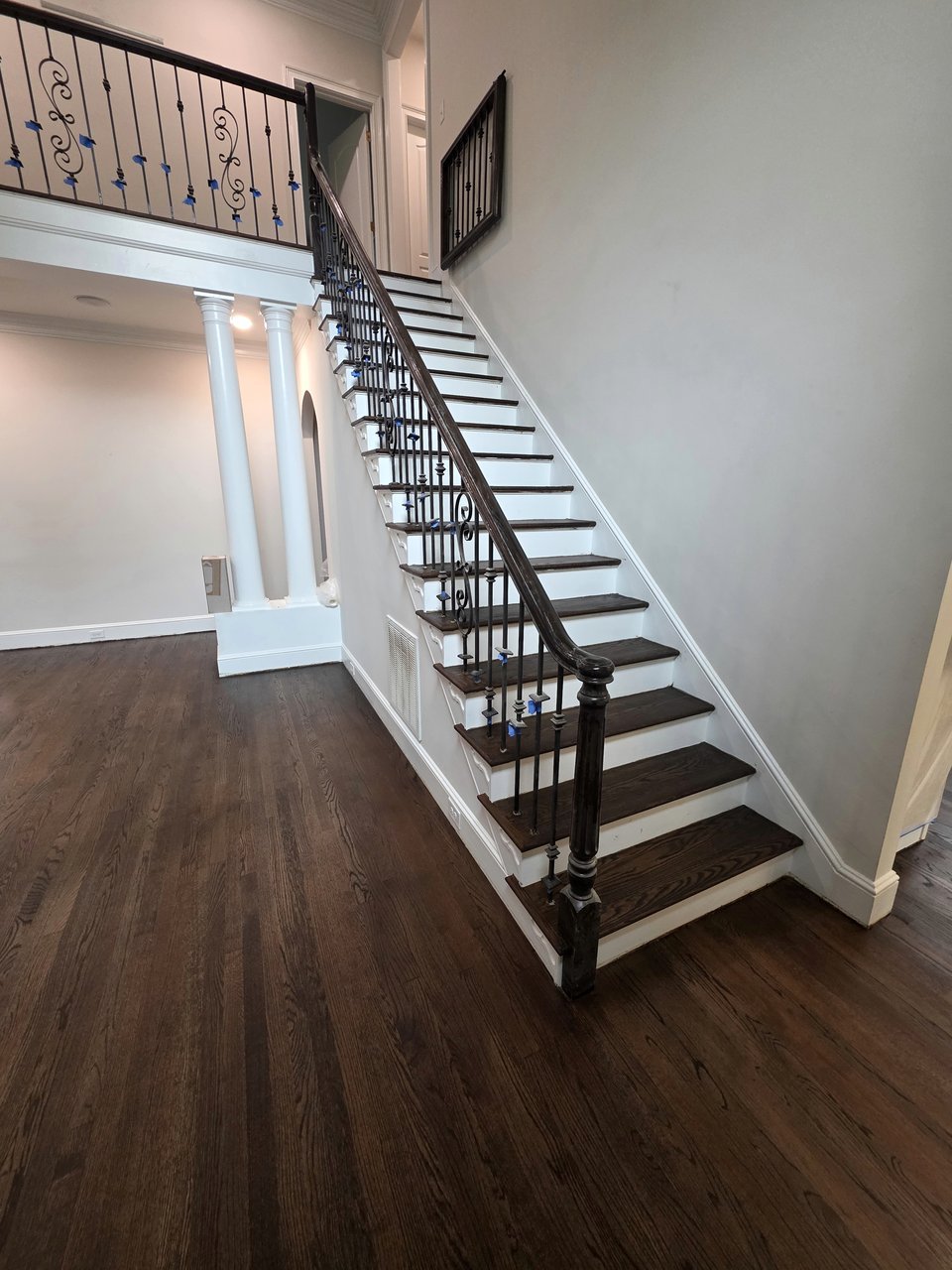 Finished curved stair treads beside iron balusters