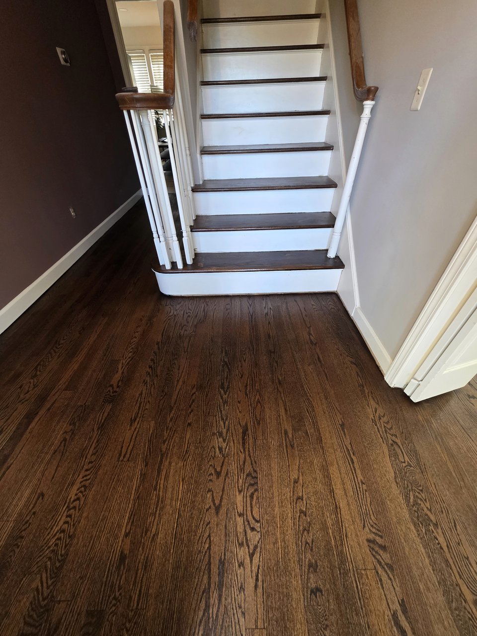 Finished wood floor at the foot of a staircase